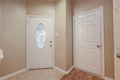 Welcoming Foyer with Elegant Glass-Inlaid Front Door | Image 3