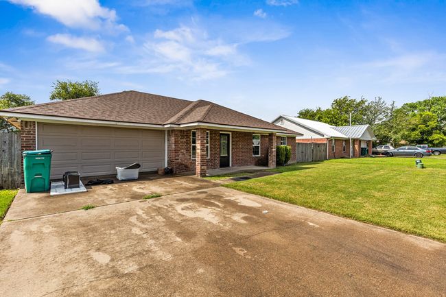 View of front of property with brick siding, driveway, roof with shingles, and an attached garage | Image 7