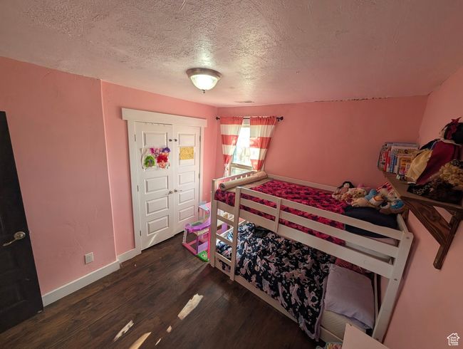 Bedroom featuring a textured ceiling, baseboards, and wood finished floors | Image 16
