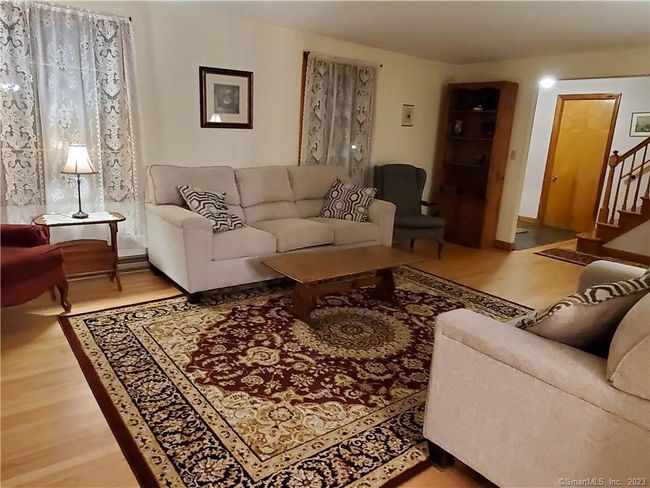 Large living room with hardwood floors and lots of windows for natural light. | Image 12