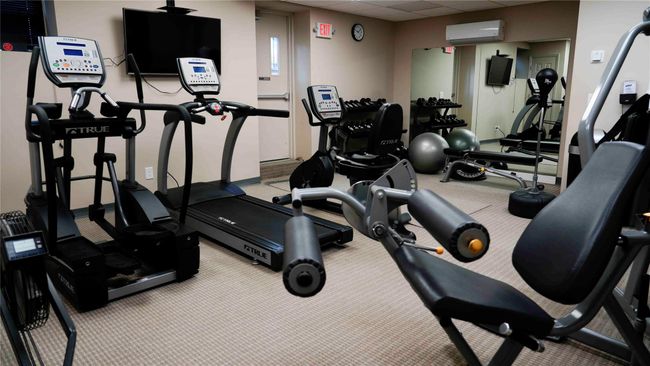 Workout area featuring a wall mounted air conditioner, carpet, and a paneled ceiling | Image 12