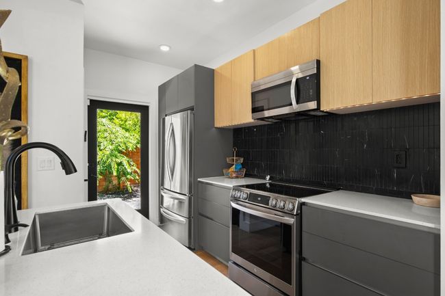 Kitchen with appliances with stainless steel finishes, light countertops, backsplash, gray cabinets, and recessed lighting | Image 11