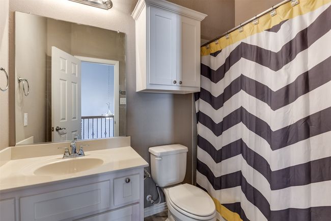 Bathroom with a shower with shower curtain, vanity, and toilet | Image 39
