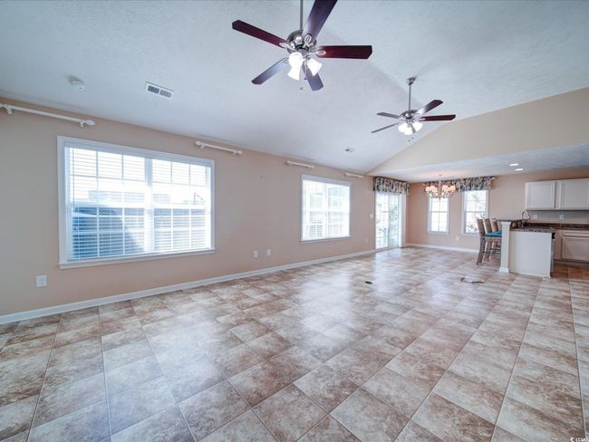 Unfurnished living room with lofted ceiling, a chandelier, and a ceiling fan | Image 10