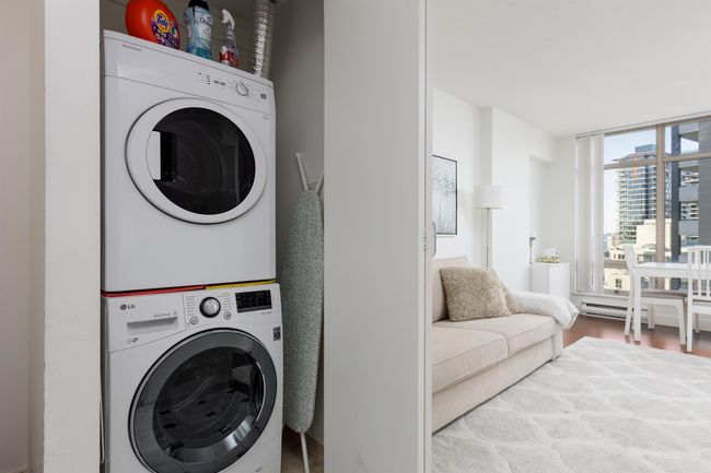 Laundry room featuring stacked washer / dryer and wood finished floors | Image 14