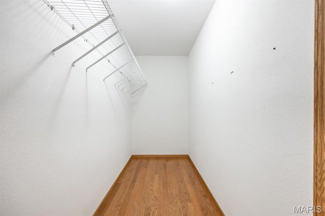 Spacious closet with light wood-type flooring | Image 39