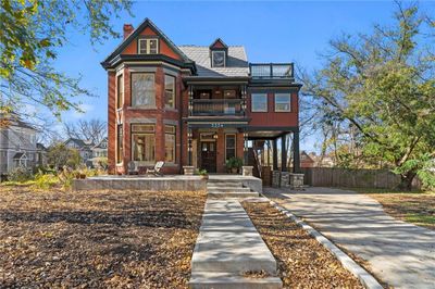 Victorian home featuring a balcony and a patio area | Image 1