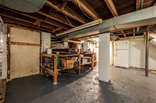 Below grade area featuring freestanding refrigerator and a workshop area | Image 18