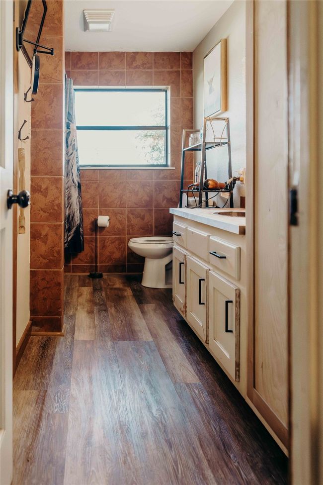 Full bathroom with vanity, wood finished floors, curtained shower, and tile walls | Image 23