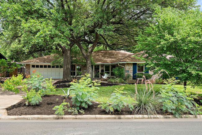 Picture-perfect curb appeal framed by mature oaks and flowering trees | Image 5