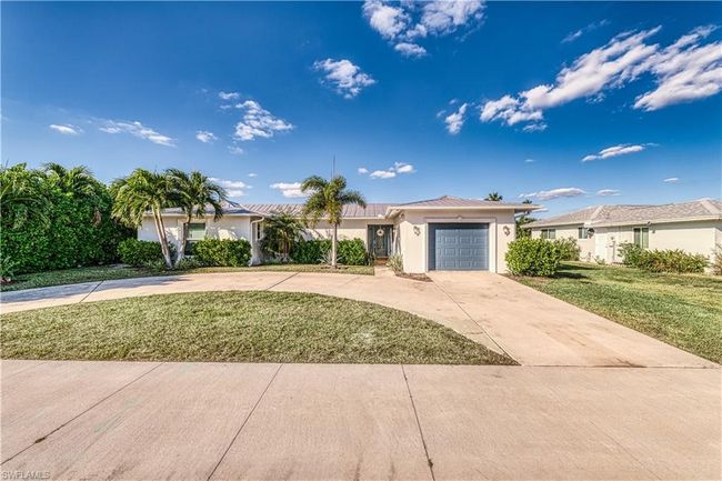 Ranch-style house with stucco siding, a garage, a front yard, and concrete driveway | Image 27