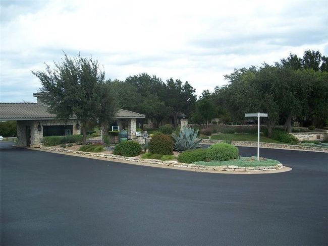 View of front of house with stone siding, driveway, and a tiled roof | Image 6