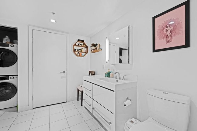 Bathroom with toilet, stacked washer / dryer, recessed lighting, vanity, and tile patterned floors | Image 19