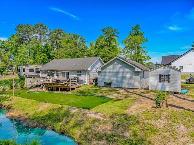 Back of house with a wooden deck and a yard | Image 32