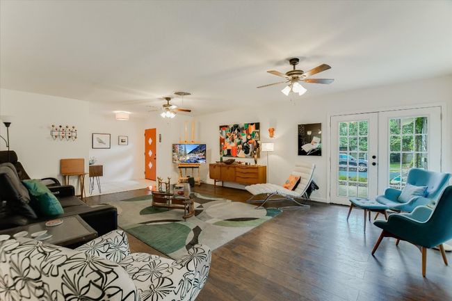 Living room with a ceiling fan, french doors, and wood finished floors | Image 5