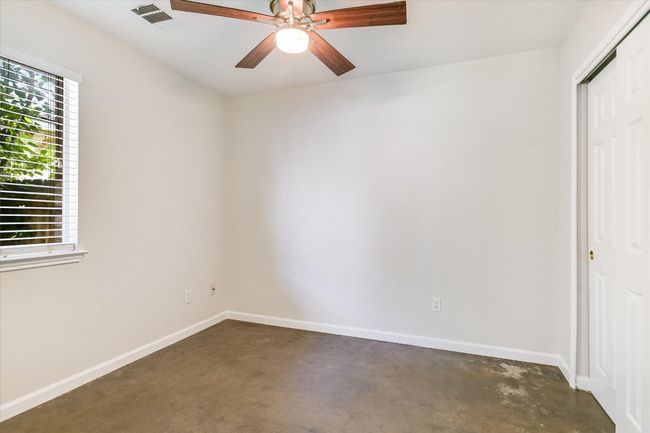 Secondary bedroom featuring concrete floors, a closet with shelving added, and modern ceiling fan large enough for a Queen and other furniture, or will it be your home office or yoga room? | Image 13