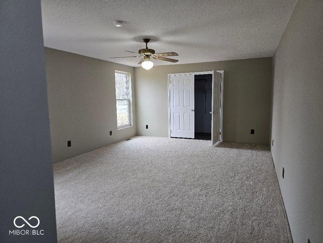 carpeted empty room featuring a textured ceiling and a ceiling fan | Image 22
