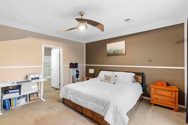 Primary bedroom with chair rail and updated fan | Image 17