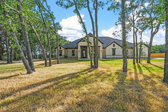 View of front facade featuring stone siding and a front lawn | Image 7
