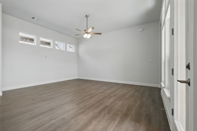 Empty room featuring dark wood finished floors, baseboards, visible vents, and ceiling fan | Image 13