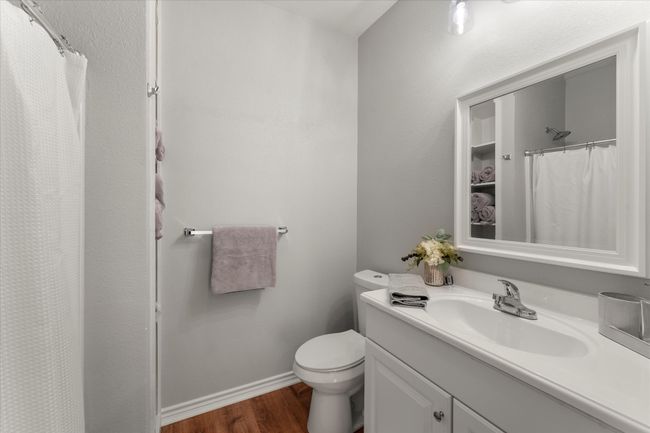 Bathroom with wood finished floors, vanity, a shower with curtain, baseboards, and toilet | Image 32