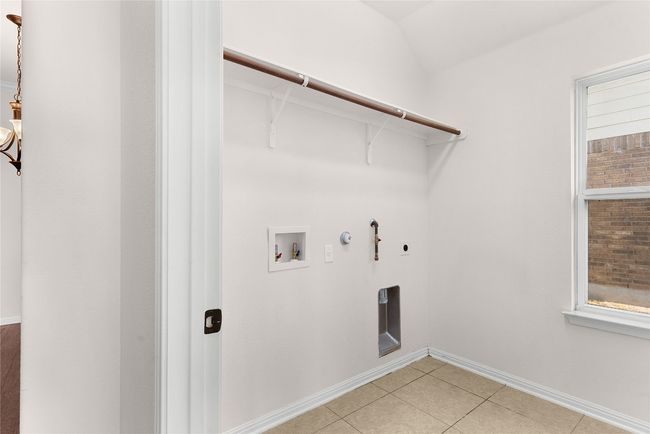 Laundry room with light tile patterned floors, gas dryer hookup, laundry area, electric dryer hookup, and washer hookup | Image 22