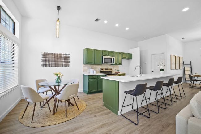 Kitchen featuring green cabinets, appliances with stainless steel finishes, light countertops, light wood-type flooring, and recessed lighting | Image 9