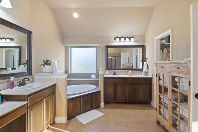 Full bath featuring a garden tub, vaulted ceiling, and a sink | Image 22