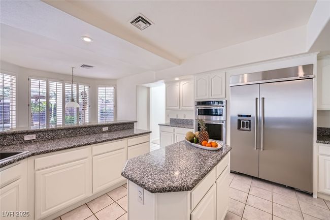 Kitchen featuring stainless steel appliances, light tile patterned flooring, visible vents, and white cabinetry | Image 27