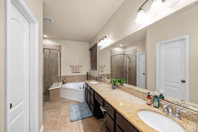Double sinks, vanity area, a large soaring tub, and spacious walk-in shower in this primary bath. | Image 21