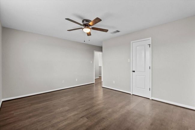 Perfect for growing families: This spacious 4th bedroom easily accommodates children or creates a comfortable guest suite. | Image 25