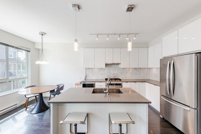 Kitchen featuring appliances with stainless steel finishes, modern cabinets, dark wood-style floors, and white cabinetry | Image 12