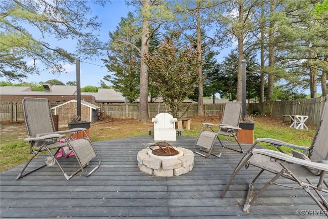 Wooden deck with an outdoor fire pit and a fenced backyard | Image 33