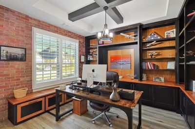 Just to the left of the front door is an office space with custom built ins and a brick feature wall | Image 3