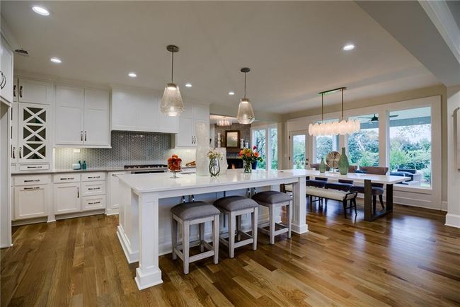 Kitchen with plenty of natural light, backsplash, white cabinetry, hardwood / wood-style floors, and pendant lighting | Image 9