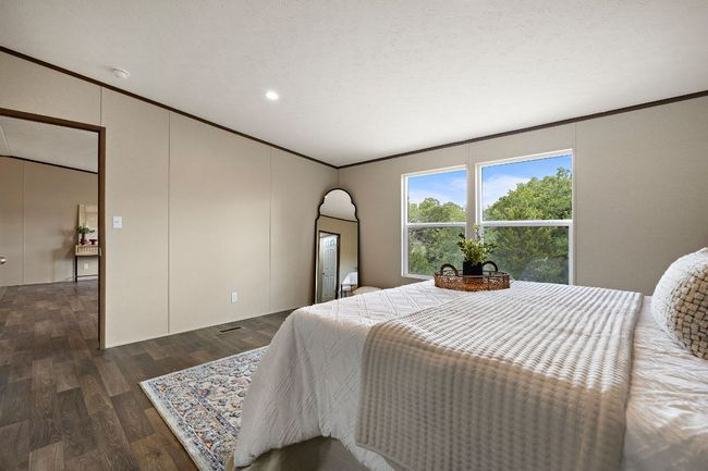 Bedroom featuring dark wood-style flooring, crown molding, and recessed lighting | Image 24