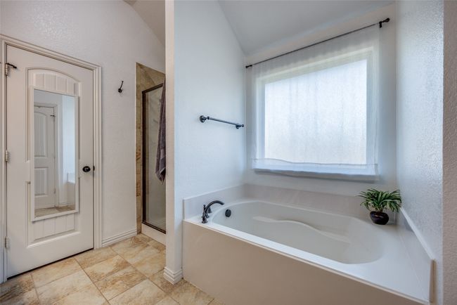Bathroom featuring shower with separate bathtub and lofted ceiling | Image 16