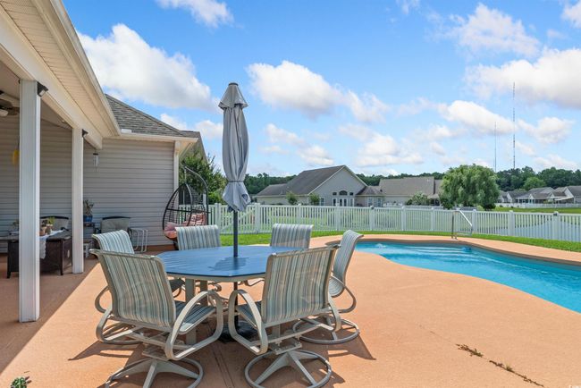 View of swimming pool with a patio, a fenced backyard, a residential view, and outdoor dining space | Image 19