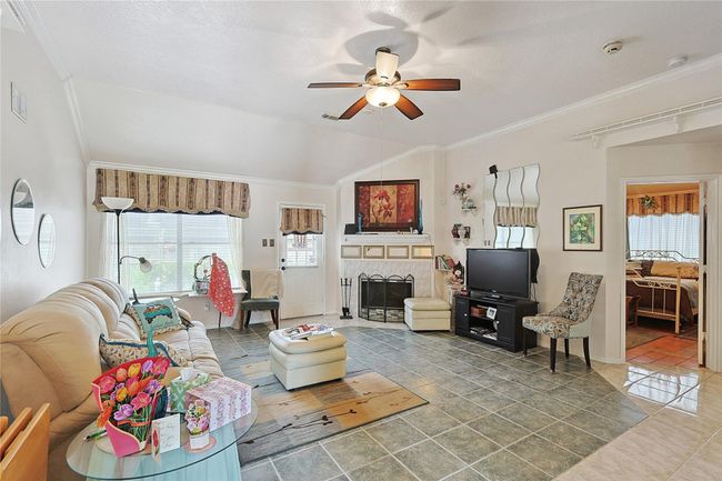Living room features a corner fireplace with flexible furniture layout, creating a cozy space for relaxing or entertaining with family and friends. | Image 11