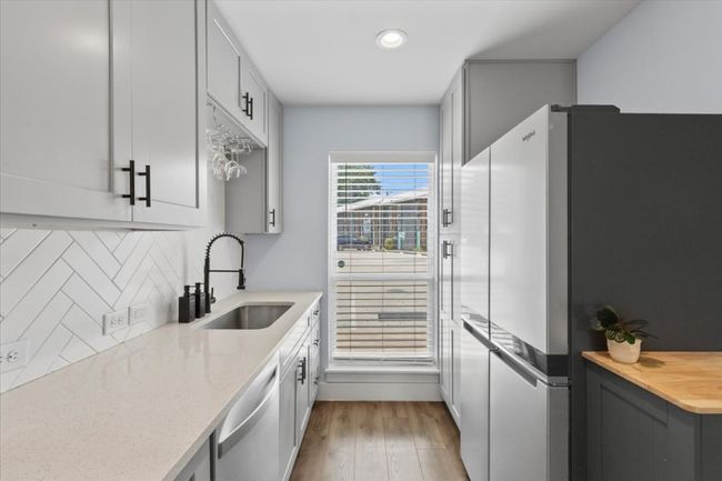 Kitchen with freestanding refrigerator, dishwasher, backsplash, wood finished floors, and recessed lighting | Image 8