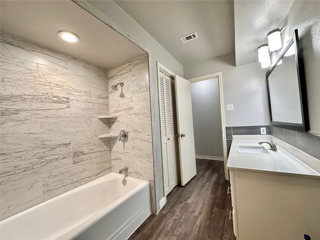 Bathroom with vanity, wood finished floors, and bathtub / shower combination | Image 28