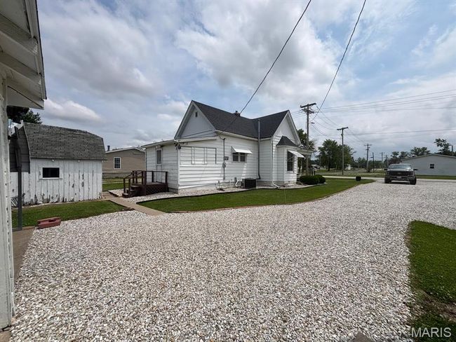 View of property exterior with central air condition unit, a yard, and driveway | Image 6