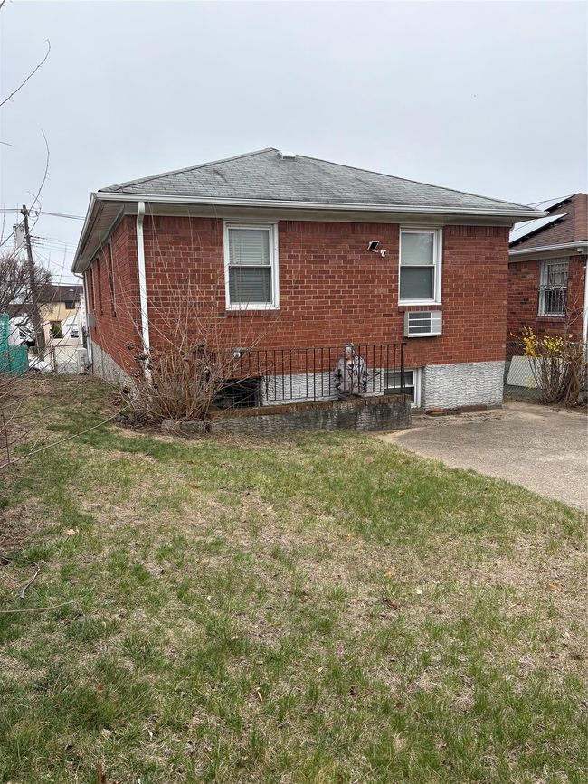 Rear view of property with a shingled roof, brick siding, and a yard | Image 17