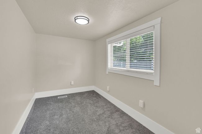 Unfurnished room featuring dark carpet, baseboards, and a textured ceiling | Image 17