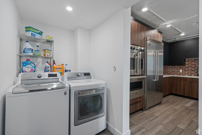 Laundry room featuring washer and clothes dryer and LVP flooring | Image 11