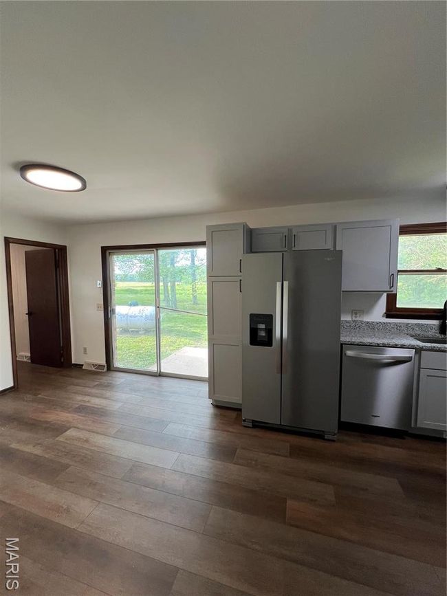 Kitchen with a wealth of natural light, dishwashing machine, gray cabinets, and refrigerator | Image 15