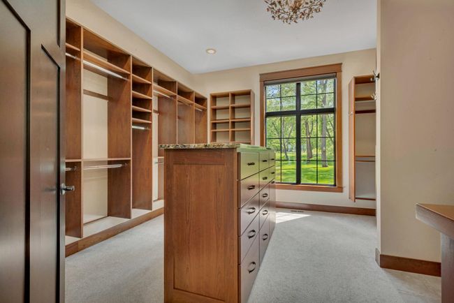 Walk-in closet featuring a central island with built-in drawers, providing stylish storage and easy organization. | Image 54