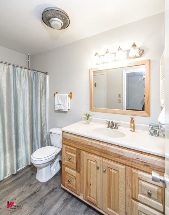 Bathroom with toilet, wood finished floors, and vanity | Image 25