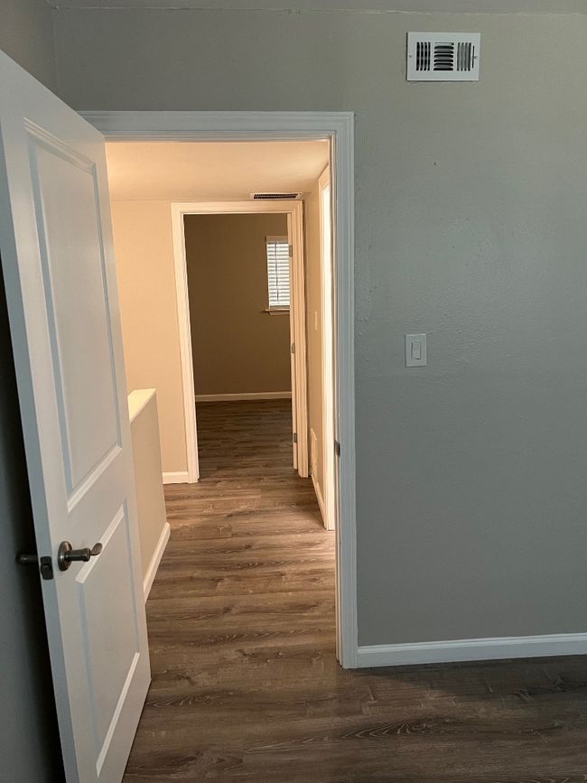 Corridor featuring visible vents, baseboards, and dark wood-style floors | Image 19