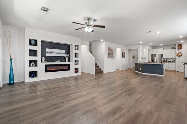 Living room with recessed lighting, ceiling fan, stairs, wood finished floors, and Custom fireplace | Image 14